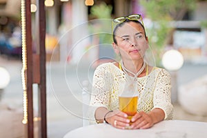 Portrait of woman drinking beer at beach cafe