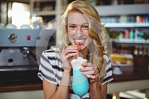 Portrait of woman drinking milkshake with a straw