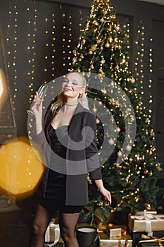 Portrait of a woman in elegant evening dress standing near christmas tree