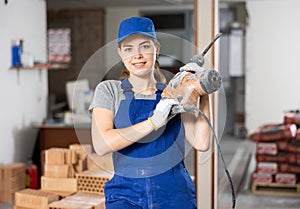 Portrait of woman engineer holding electric hammer