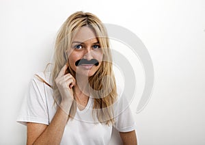 Portrait of woman in fake mustache against white background