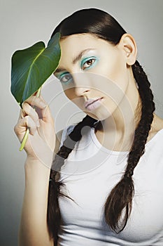 Portrait of woman with fashion make up with blue eye and leaf on