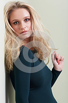 Portrait, woman and fashion in studio with confidence, attitude or elegance against wall background. Style, face and
