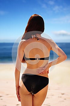 Portrait of woman flaunting her bottom in bikini.Sun Cream. Skin and Body Care. Sunscreen to Her Skin. photo