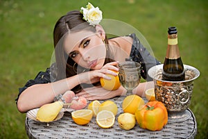 Portrait of woman with fresh fruit on a table in park outdoors. Healthy vegetarian food, healthcare. Sensual young woman