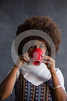 Portrait of woman with frizzy hair drinking coffee