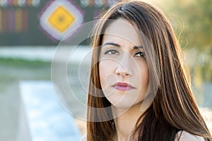 Portrait of a woman front view 30s, thinking., serious, outdoors.