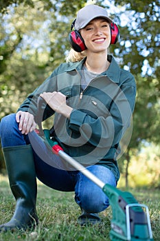 Portrait woman gardener using mowing grass