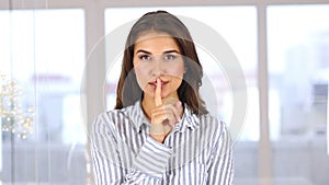 Portrait of woman gesturing silence, finger on lips