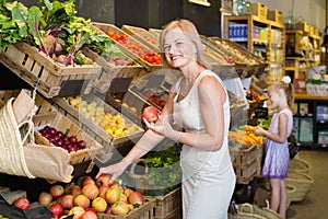 Portrait of woman and girl buying fresh fruits