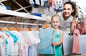 Portrait of woman and girl shopping kids apparel in clothes sto