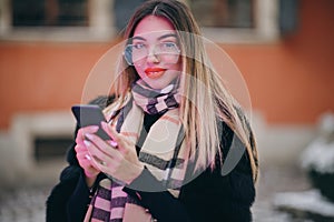 Portrait woman with glasses look at camera poses in city center Beautiful hair attractive smile girl. Close shot on