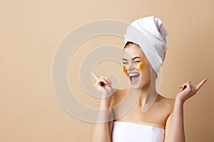 portrait woman golden patches on the face with a towel on the head beige background