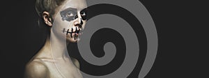 Portrait of woman with Halloween skeleton make up. Horror spooky skull visage concept with copy-space banner background