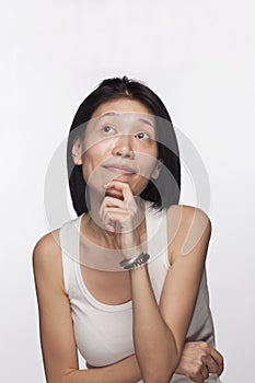 Portrait of woman with hand on her chin looking up in contemplation