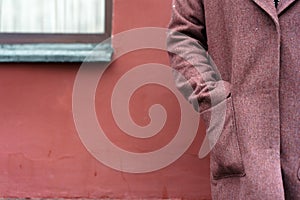 Portrait of a woman hand in the pocket in a burgundy coat view from the back