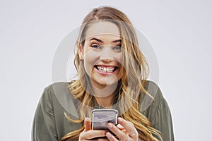 Portrait, woman and happy with phone in studio for, social media, networking and smile. Gen z, female person and