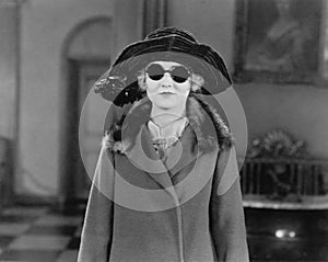 Portrait of woman in hat, sunglasses and coat