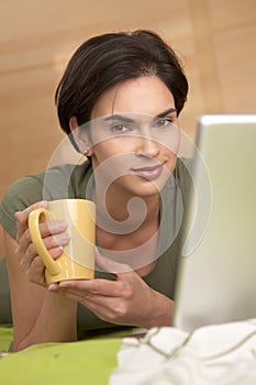 Portrait of woman having coffee in bed