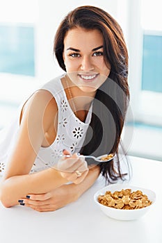 Portrait of woman having healthy breakfast and smiling at the ca