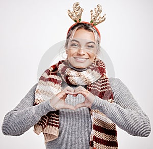 Portrait, woman and heart with smile at Christmas for festive, winter and holiday on studio backdrop. Female person