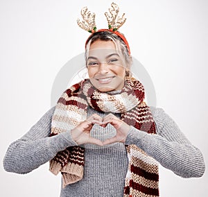 Portrait, woman and heart with smile at Christmas for festive, winter and holiday on studio backdrop. Female person