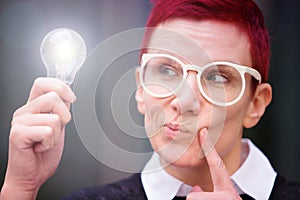 Portrait of woman holding a glowing lightbulb