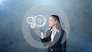 Portrait of woman holding painted watch mechanism on the open hand palm, isolated studio background. Business concept.