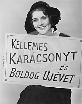 Portrait of woman holding sign written in foreign language