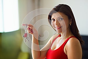 Portrait woman home owner smiling holding keys new house