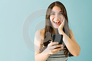 Portrait of a woman that just received very good news on her cellphone