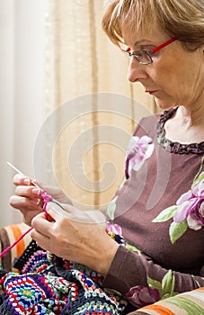 Portrait of woman knitting a vintage wool quilt