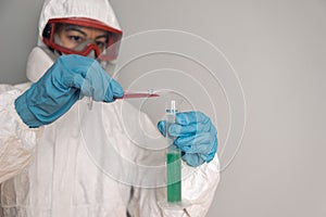 Portrait of woman with lab coat, nitrile gloves, goggles, face mask and NBC protection suit for covid-19 coronavirus,