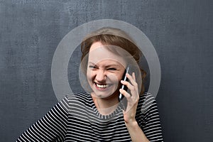 Portrait of woman laughing and talking on phone