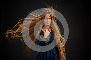 Portrait of woman with long explosive wavy red hair .