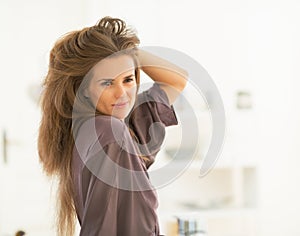 Portrait of woman with long hair looking in mirror