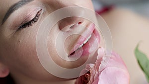 Portrait of a woman lying in the bathroom with foam and holding a pink rose