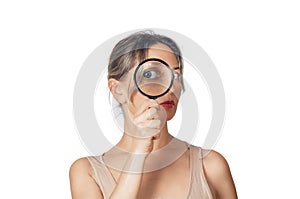 Portrait of woman with magnifying glass looking at camera with big zoom eye, checking authenticity. Authenticate, choice concept photo