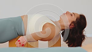 Portrait of a woman meditating on the yoga blocks in the savasana pose in a room