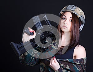 Portrait of a woman in a military uniform with an assault rifle