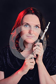 Portrait of a woman musician with a piccolo flute on a studio black background. Flutist with a small flute in her hands