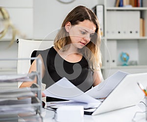 Portrait of woman office worker doing paperwork