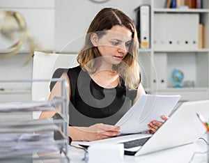 Portrait of woman office worker doing paperwork