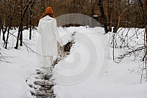 portrait of a woman outdoors in a field in winter walking with a dog fresh air