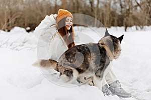 portrait of a woman outdoors in a field in winter walking with a dog Lifestyle