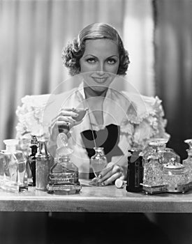 Portrait of woman with perfume bottles photo