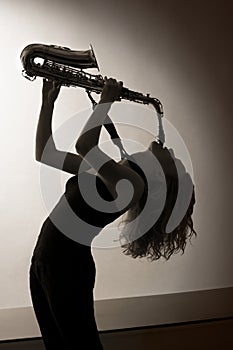 Portrait of woman playing saxophone, sepia toned.