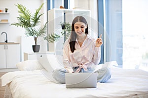 Portrait of woman pointing finger up sign of having idea working on laptop.