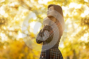 Portrait of a woman praying in nature, the girl thanks God with her hands folded at her chin, a conversation with the Creato