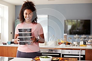 Portrait Of Woman Preparing Batch Of Healthy Meals At Home In Kitchen